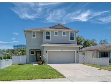 Charming two-story home features a well-maintained lawn, two-car garage, and a light blue exterior at 4212 W La Salle St, Tampa, FL 33607