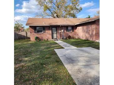 Charming brick home with a well-maintained lawn and concrete walkway leading to the front door at 5119 Hector Ct, Tampa, FL 33624