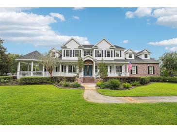 Stately two-story home with lush lawn, brick accents, covered porch, and beautiful gazebo at 8410 Kenavis Pl, Odessa, FL 33556