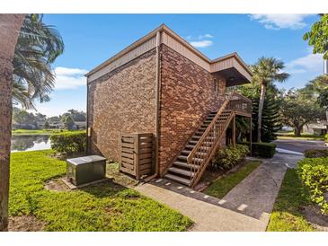 Brick apartment building with stairs leading to the second floor and beautiful landscaping at 10423 Carrollbrook Cir # 203, Tampa, FL 33618