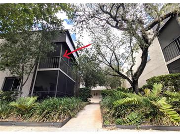 A condo featuring a screened balcony surrounded by lush landscaping at 11705 Raintree Village Blvd # C, Temple Terrace, FL 33617