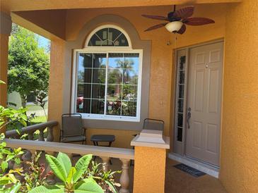 Charming front porch features neutral colors, a ceiling fan, and a sunny window at 1855 Briland St, Tarpon Springs, FL 34689