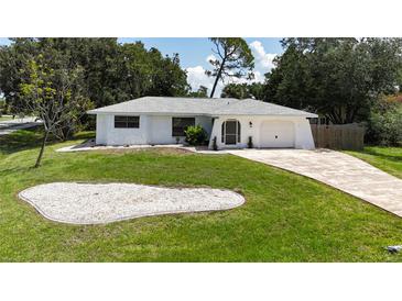 Charming single-story home with a well-maintained lawn, driveway, and a one-car garage at 21426 Quesada Ave, Port Charlotte, FL 33952