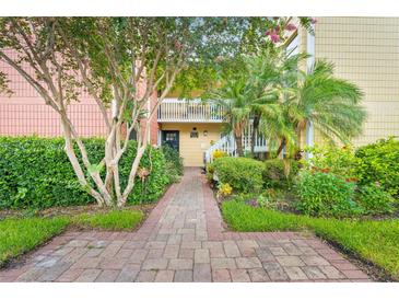 Inviting condo exterior with lush landscaping and a charming brick walkway leading to the entrance at 2424 W Tampa Bay Blvd # G204, Tampa, FL 33607
