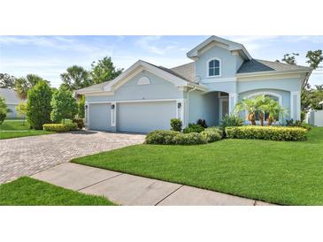 Charming single-Gathering home featuring a well-manicured lawn, 3 car garage, and lush landscaping at 26 Concord Dr, Dunedin, FL 34698