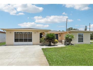 Charming single-story home with lush landscaping, a driveway, and a screened-in garage in a well-maintained community at 3401 Pinon Dr, Holiday, FL 34691