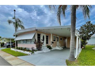Charming single-story home with covered parking, inviting entrance, and beautifully landscaped front yard at 34091 Alamanda N Dr, Pinellas Park, FL 33781