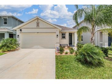 Charming single-Gathering home showcasing a well-manicured lawn and a two-car garage on a sunny day at 8310 Hardy Bay Loop, Wesley Chapel, FL 33545