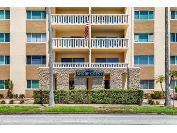 Low angle of the building's facade featuring stone accents, balconies, and the Shore Crest sign at 1200 N Shore Ne Dr # 404, St Petersburg, FL 33701