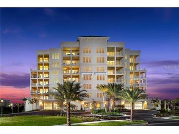 Stunning multi-story condominium with manicured lawn and palm tree landscaping, showcasing luxury coastal living at twilight at 125 Belleview Boulevard # 203, Belleair, FL 33756