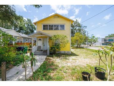 Charming two-story home with a sunny yellow exterior, featuring a quaint porch and simple landscaping at 214 W Hanna Ave # A, Tampa, FL 33604