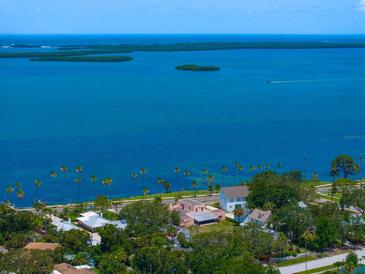 Expansive aerial view showcases waterfront property with lush landscaping and bay views at 43 Edgewater Dr, Dunedin, FL 34698