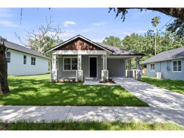 Charming single-story home features a well-manicured lawn and inviting covered front porch at 5707 N 20Th St, Tampa, FL 33610