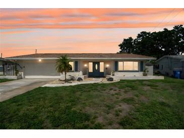 Charming single-story home with a well-manicured lawn and a welcoming front entrance at sunset at 6236 17Th S St, St Petersburg, FL 33712
