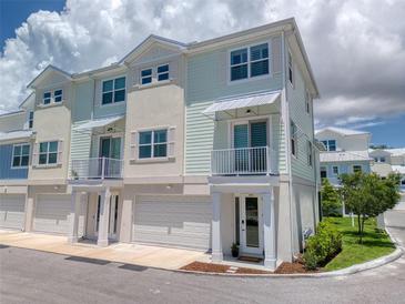 Charming townhome with pale green siding, white trim, balcony, and garage at 803 Oak Bend Ln, Dunedin, FL 34698