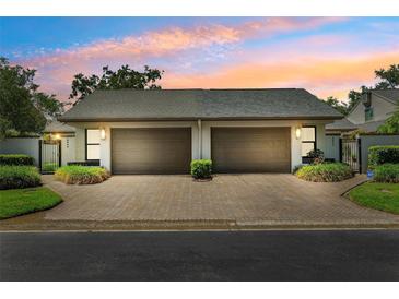 Charming home exterior features a symmetrical facade with two garages and updated landscaping at 8645 Piper Ln, Seminole, FL 33777