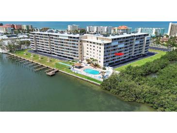 An aerial view of a waterfront condo complex with a pool and boat docks and access to the bay at 19451 Gulf Blvd # 205, Indian Shores, FL 33785