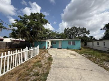 Charming single-story home featuring a light blue exterior, white trim, and a concrete driveway at 2175 20Th Sw Ave, Largo, FL 33774