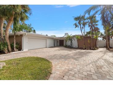 Stunning single-story home with a two-car garage, beautiful paver driveway, and lush tropical landscaping at 3830 46Th S Ave, St Petersburg, FL 33711