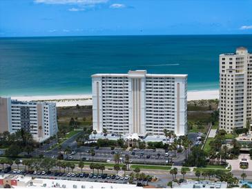 Stunning aerial view of beachfront condos with manicured grounds and ample parking at 1230 Gulf Blvd # 304, Clearwater, FL 33767