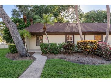 Charming single-story home featuring lush landscaping and a welcoming walkway at 1380 Azalea Dr # 1701, Dunedin, FL 34698