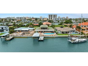 Stunning waterfront home featuring a private dock, boat lift, and inviting swimming pool for luxurious coastal living at 333 Midway Is, Clearwater Beach, FL 33767
