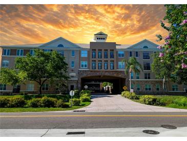 Attractive condo building exterior featuring a covered entry and well-maintained landscaping at sunset at 4221 W Spruce St # 2218, Tampa, FL 33607