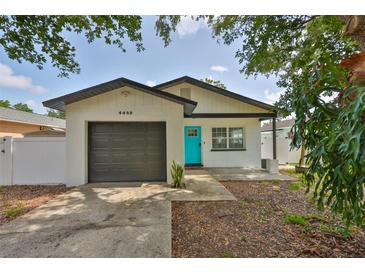 Charming single-story home with a gray garage door and bright turquoise front door at 4489 57Th N Ave, St Petersburg, FL 33714