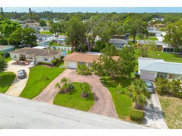 Aerial view of a single-Gathering home featuring a brick driveway, well-manicured lawn, and mature trees at 5262 25Th N Ave, St Petersburg, FL 33710
