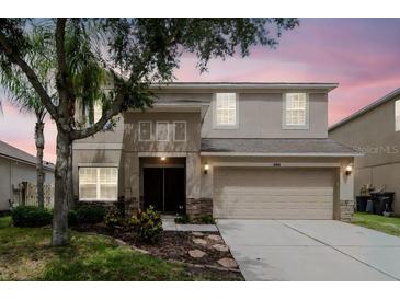 Two-story home featuring a front-facing two car garage and neutral color palette at 5916 Tulip Flower Dr, Riverview, FL 33578