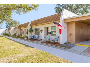 Inviting single-story villa featuring a charming front patio and an American flag for added curb appeal at 1371 Mission Hills Blvd, Clearwater, FL 33759