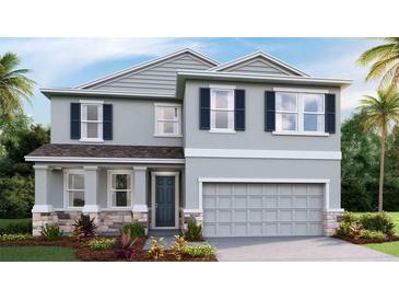 Inviting two-story home featuring a gray exterior, complemented by a well-manicured lawn and lush landscaping at 2328 Stratten Dr, Zephyrhills, FL 33541