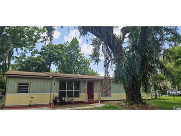Cozy single-story home featuring yellow and green siding and mature trees at 2503 Elm St, Seffner, FL 33584