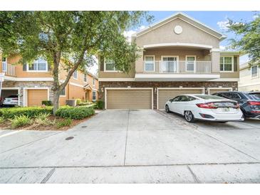 Charming townhome featuring a private balcony, stone accents, and a two-car garage at 7001 Interbay Blvd # 192, Tampa, FL 33616