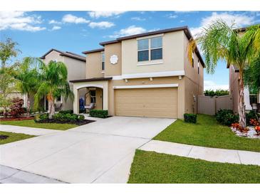 Inviting two-story home with a well-manicured lawn, a neutral color scheme, and an attached two-car garage at 7017 Gomez Rocks Ct, Sun City Center, FL 33573