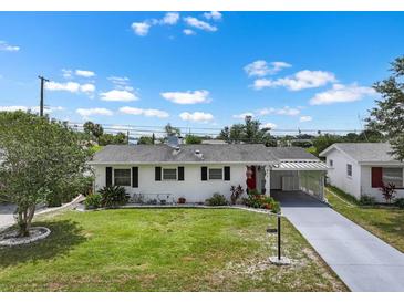 Charming single story home featuring a well-manicured lawn and a covered carport at 913 Augusta Dr, Sun City Center, FL 33573