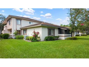 Well maintained two-story home with a green lawn, tasteful landscaping, and neutral color palette at 1851 Bough Ave # A, Clearwater, FL 33760
