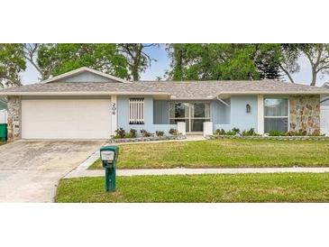 Charming single-story home featuring a well-maintained lawn and attached two-car garage at 206 Hillcrest Dr, Safety Harbor, FL 34695