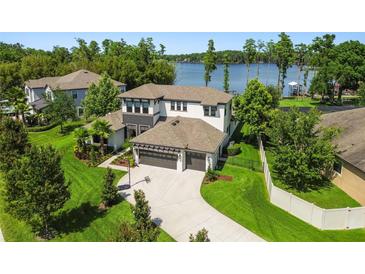 Stunning two-story home with lush landscaping, long driveway, and a serene lake view at 2648 Lake Manor Dr, Land O Lakes, FL 34639