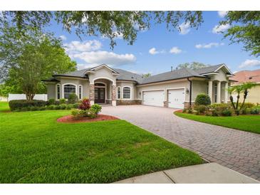 Stunning home showcasing lush landscaping, a paver driveway, and a three-car garage at 505 Vintage Way, Brandon, FL 33511