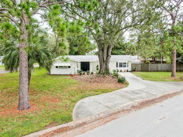 Charming single-story home with a well-manicured lawn, mature trees, and a winding driveway at 5625 Atlantic N Ave, St Petersburg, FL 33703