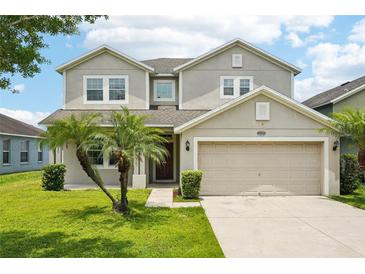 Charming two-story home featuring a well-manicured lawn and a two-car garage at 7509 Tangle Bend Dr, Gibsonton, FL 33534
