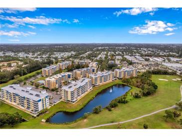 Scenic aerial view of resort-style condos with a pond and golf course in a sunny, beautiful location at 960 Starkey Rd # 7503, Largo, FL 33771