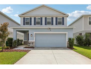Charming two-story home featuring blue shutters, a two-car garage, and manicured landscaping at 10580 Gliding Eagle Way, Land O Lakes, FL 34638