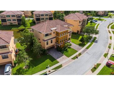 Stunning Mediterranean-style townhome with a tile roof, manicured lawn and brick paved driveway at 1536 Ember Ln, Tarpon Springs, FL 34689