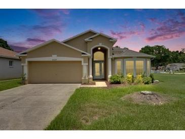 Charming single-story home with a well-manicured lawn and inviting curb appeal at dusk at 25327 Seven Rivers Cir, Land O Lakes, FL 34639
