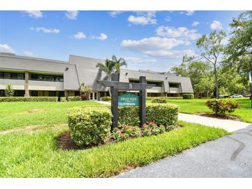 Well-maintained condo complex with lush landscaping and clear signage under a bright blue sky at 36750 Us 19 N # 20311, Palm Harbor, FL 34684
