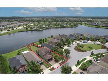 Aerial view of a lovely home with lake view and community pool area at 10081 Sage Creek Dr, Sun City Center, FL 33573