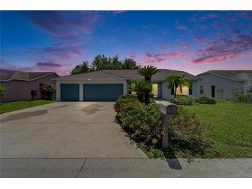 Charming home featuring a three-car garage, well-kept lawn, and lush landscaping at 2719 Wilder Trace Ct, Plant City, FL 33566