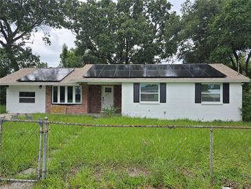 Charming home featuring white painted brick, modern solar panels, and a cozy front yard at 3614 E Grove St, Tampa, FL 33610